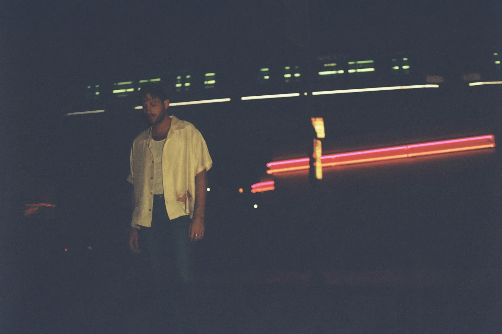 BURNS at night beneath streaks of red neon light