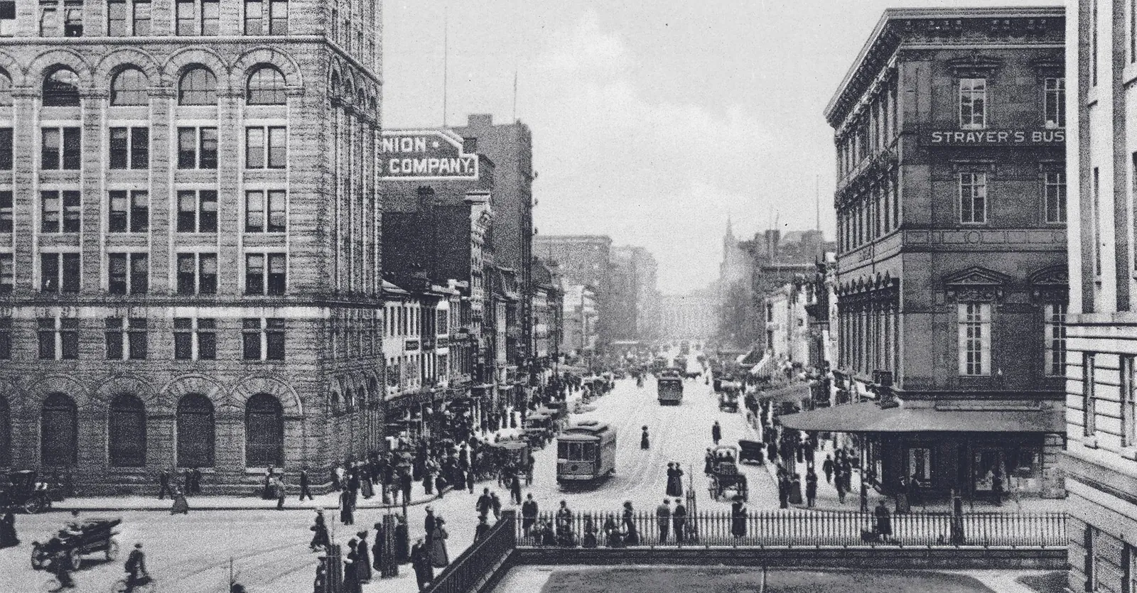 A historic photograph of a busy downtown Washington street with streetcars