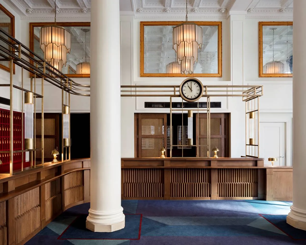 The reception desk beneath brass fixtures and a station clock